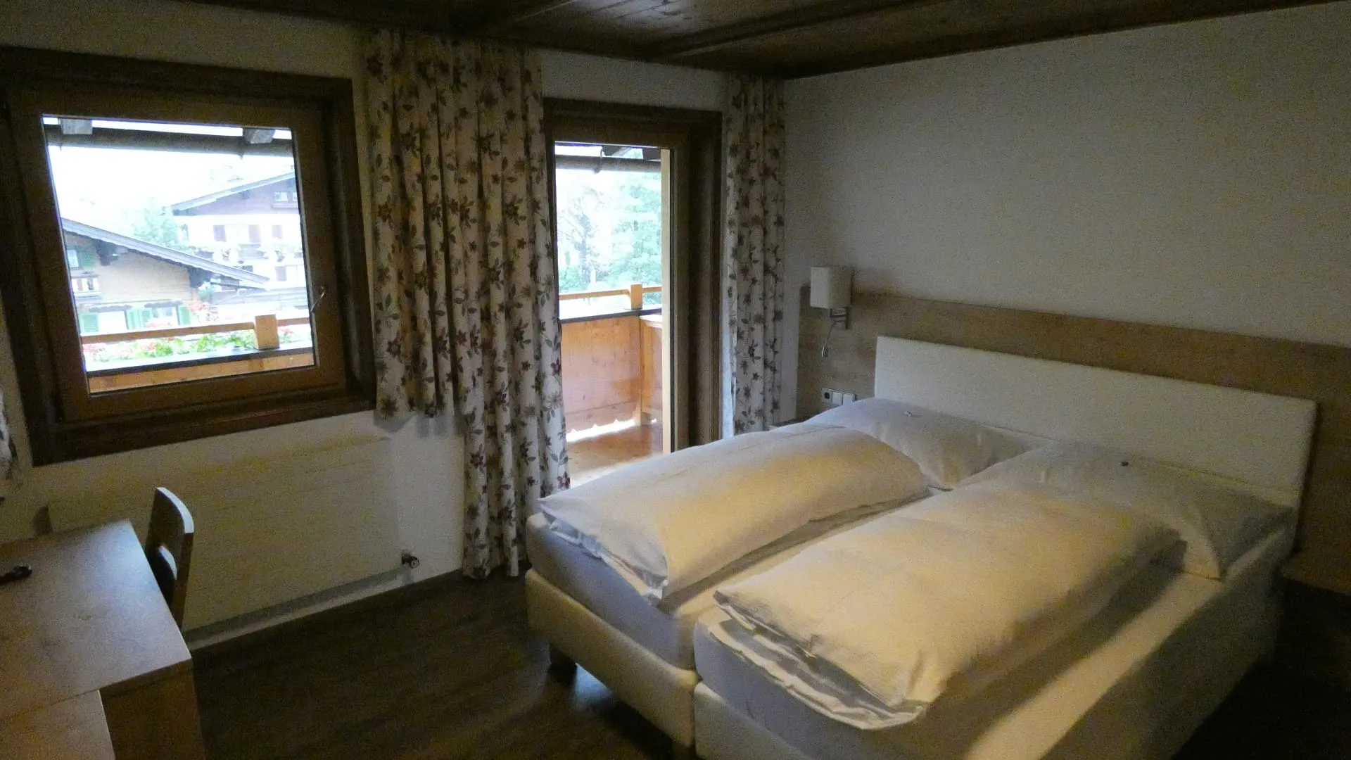 Helles Schlafzimmer mit Doppelbett und Fenster zum Balkon