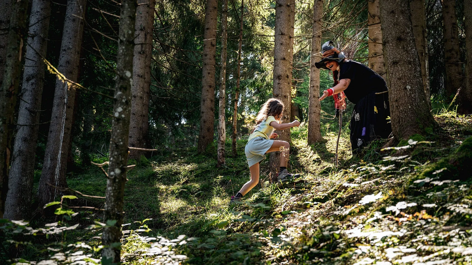 Waldszene mit einem Kind und einem Erwachsenen, die im Hexenwald wandern.