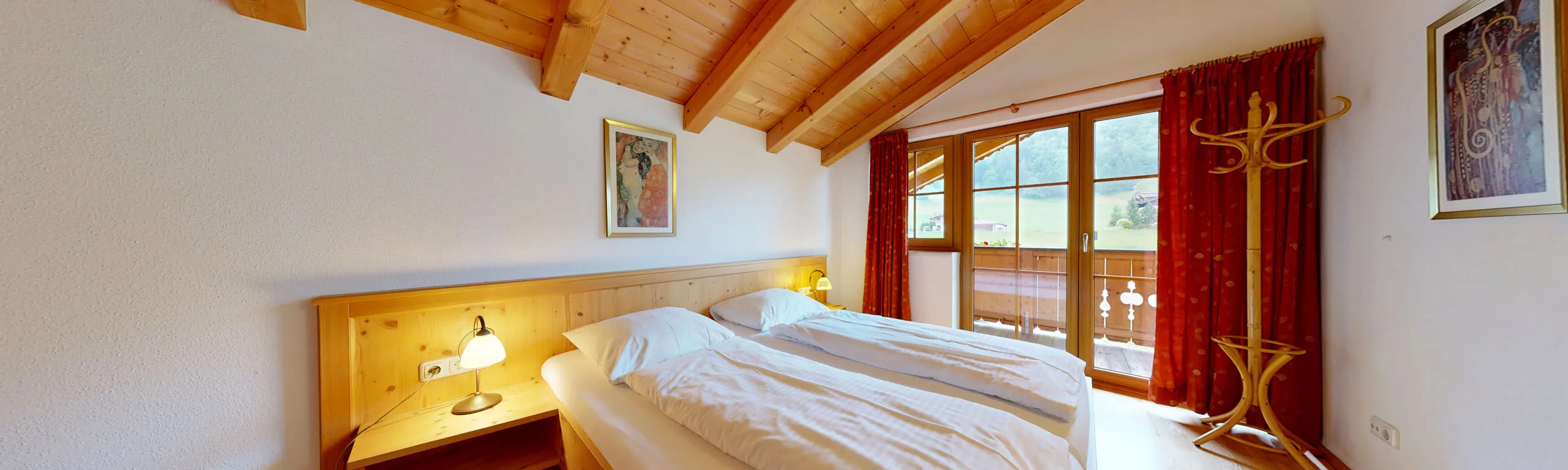 Helles Schlafzimmer mit Holzdekor, Fenster und rotem Vorhang.