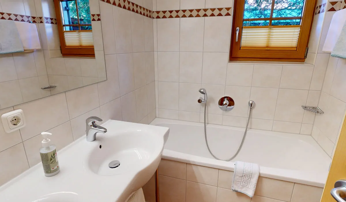 Badezimmer mit Waschbecken, Badewanne und Fenster