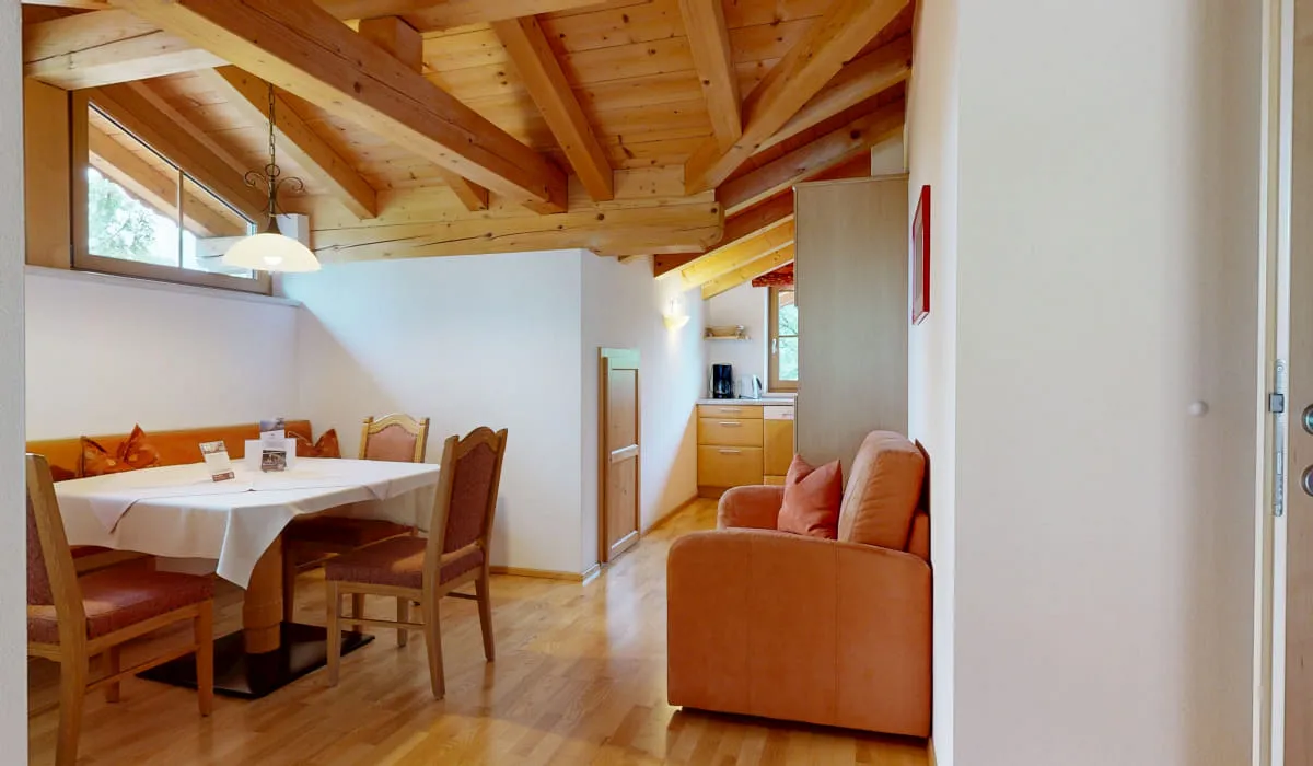 Helle Wohnküche mit Holzbalkendecke, Essbereich und Sitzecke