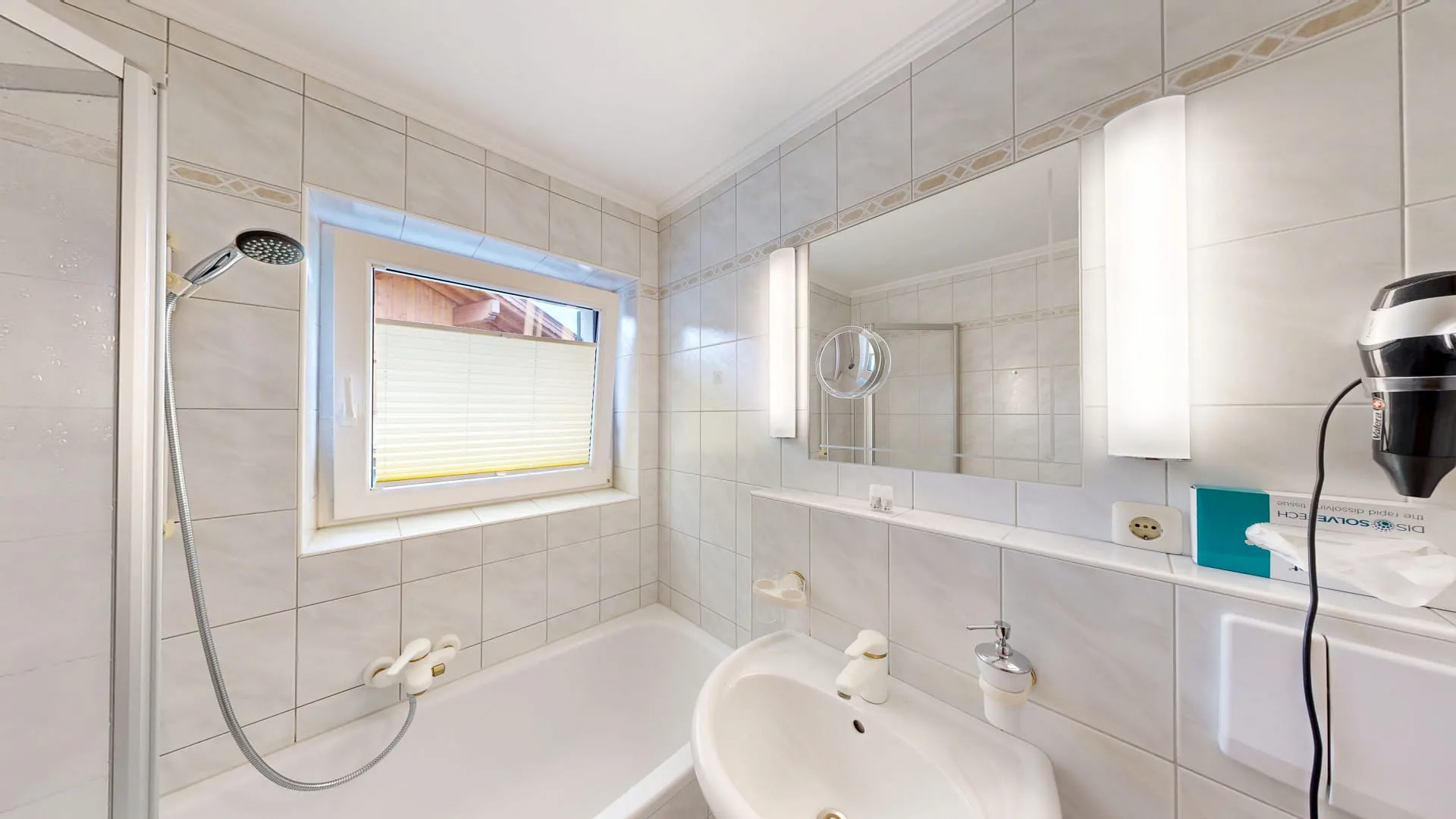 Badezimmer mit Dusche, Badewanne und Fenster, helle Fliesen und Spiegel