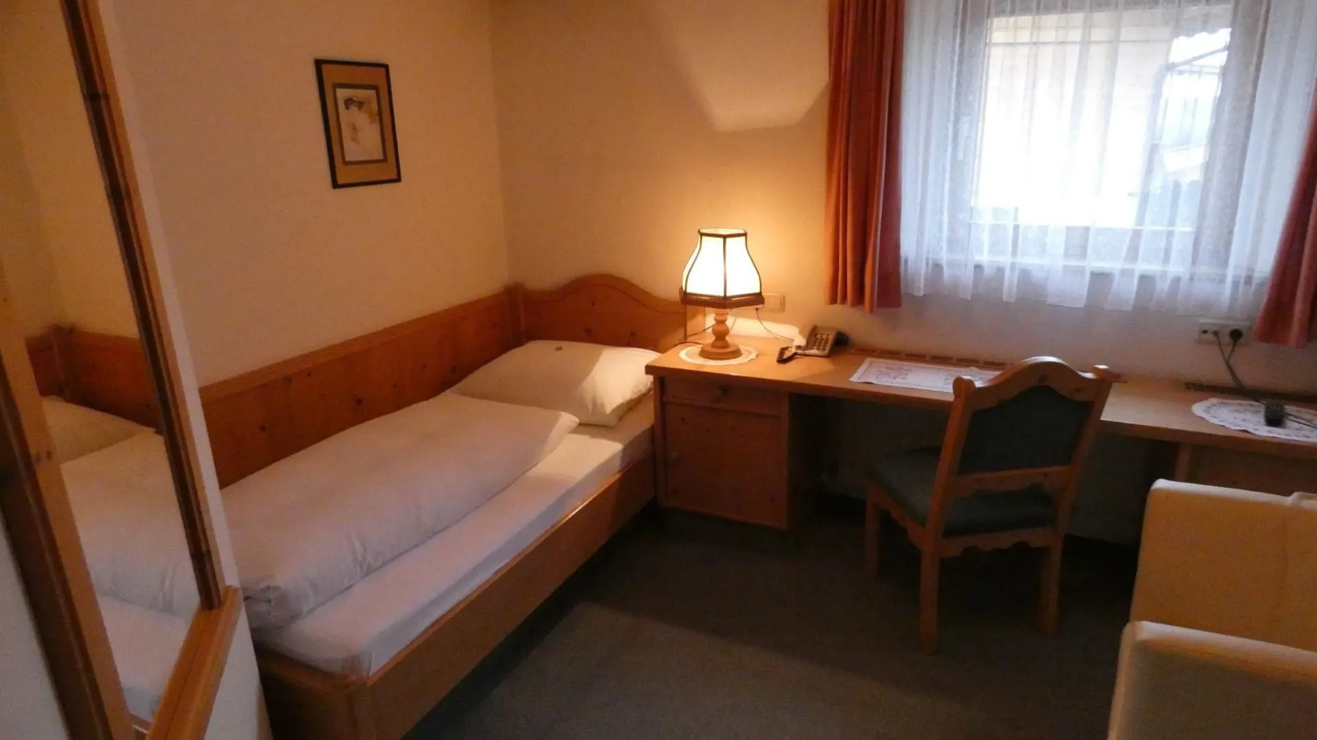 Schlafzimmer mit einem Bett, Schreibtisch und Lampe